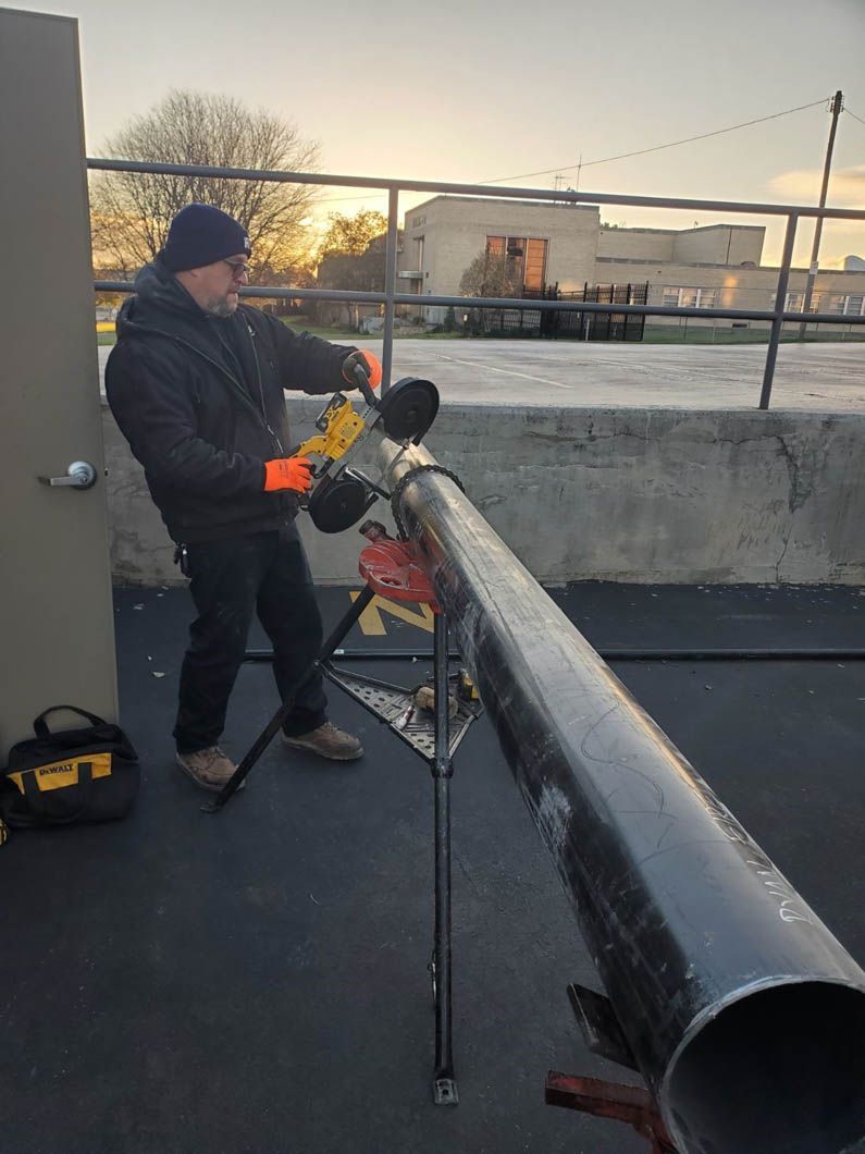 A man is cutting a pipe with a pair of pliers.