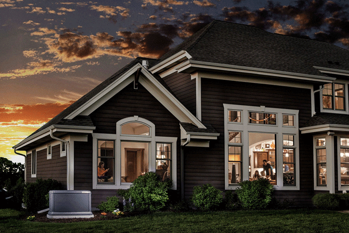 A large house with a lot of windows is lit up at night.