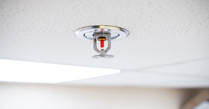 A fire sprinkler is hanging from the ceiling of a room.