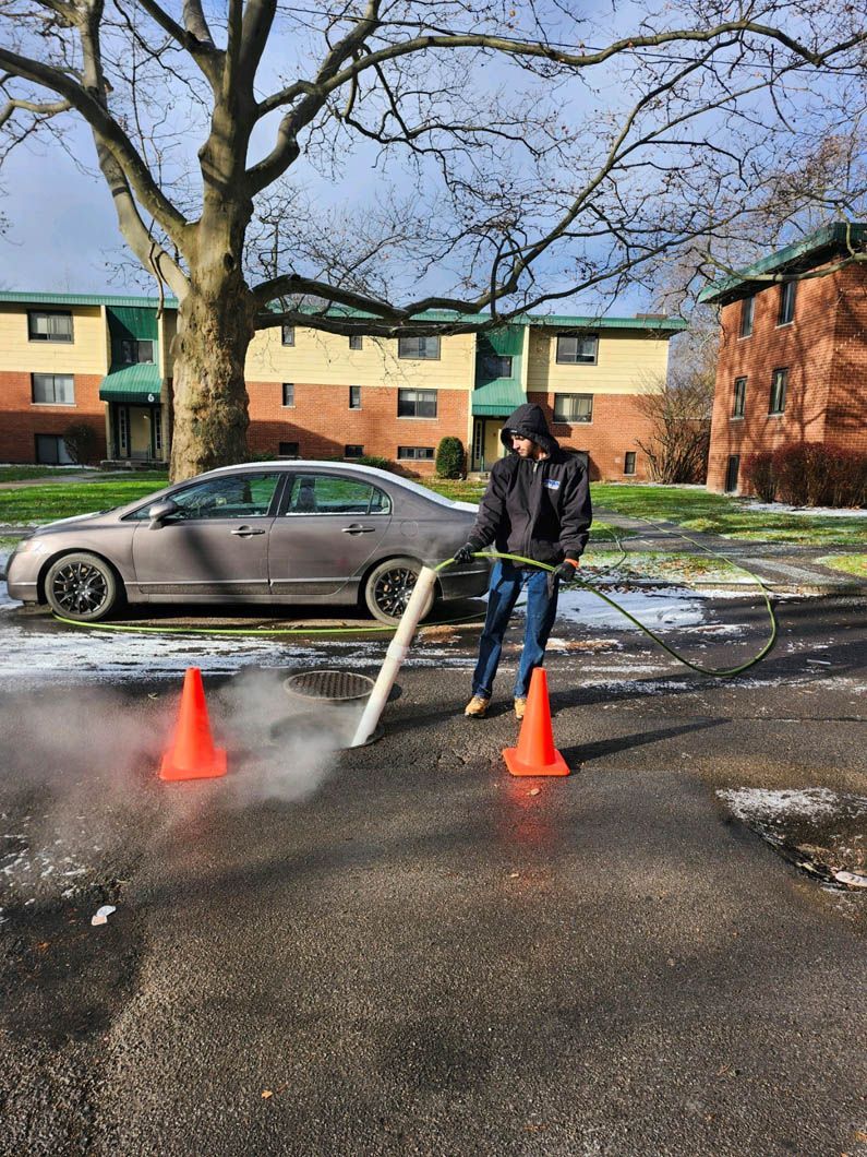 A man is cleaning a parking lot with a vacuum cleaner.