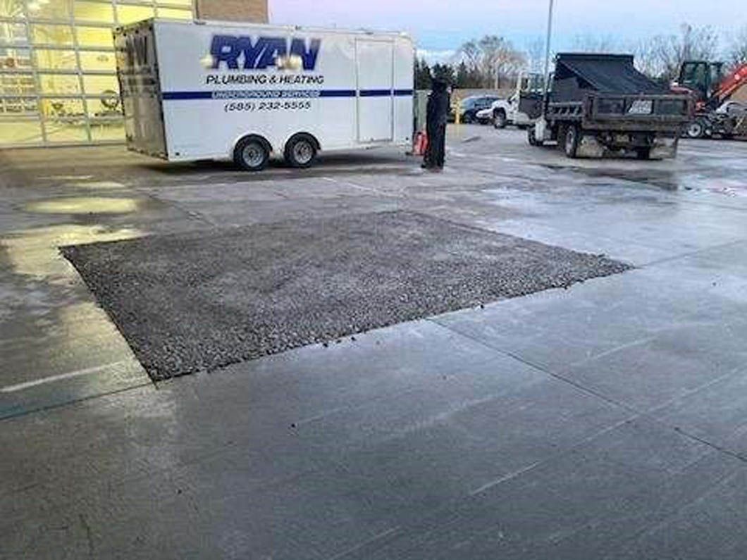 A trailer is parked in a parking lot next to a truck.