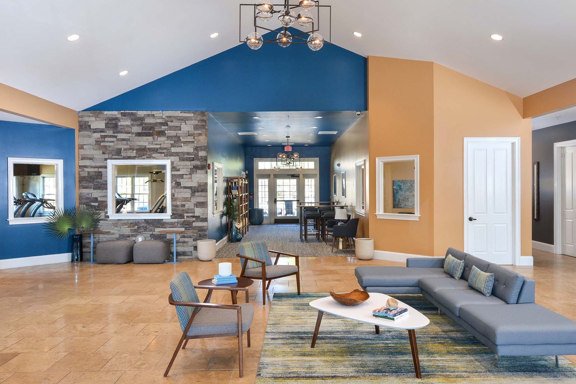Bright lobby with blue walls, a stone accent wall, and contemporary seating.