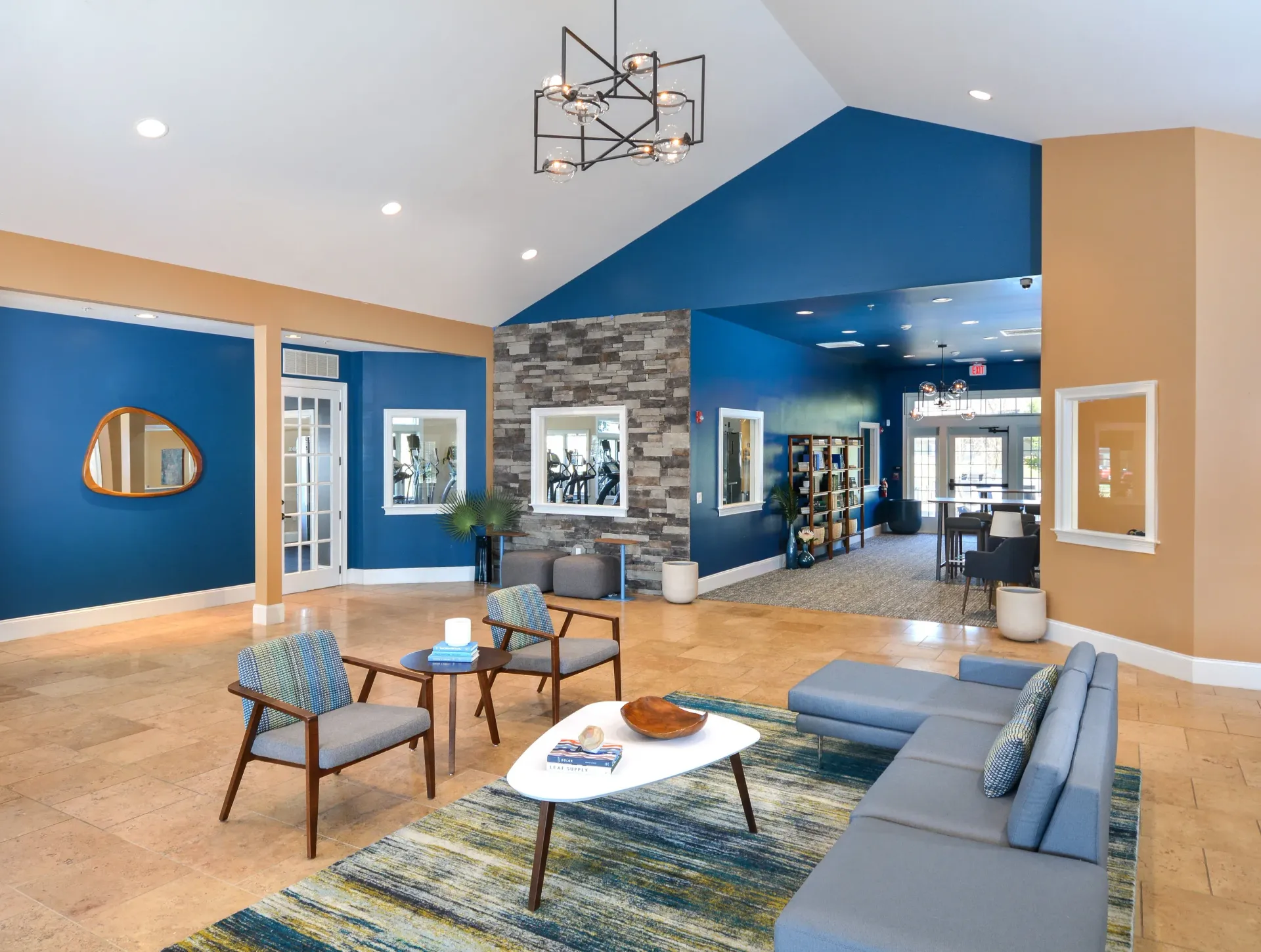 Lobby-style resident lounge with blue walls, beige columns, and stone accent wall.