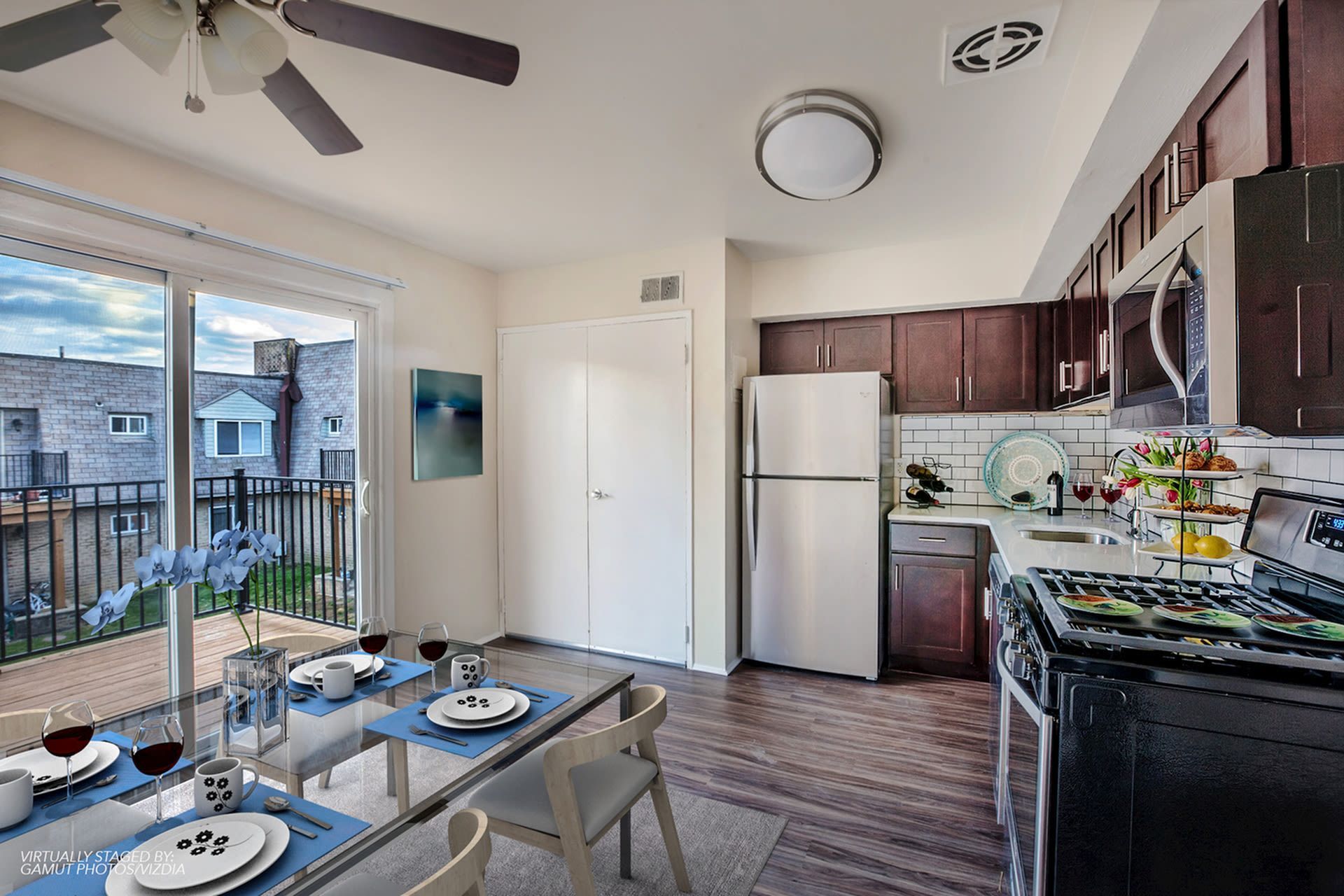 Open-concept kitchen with stainless steel appliances and sliding balcony doors.