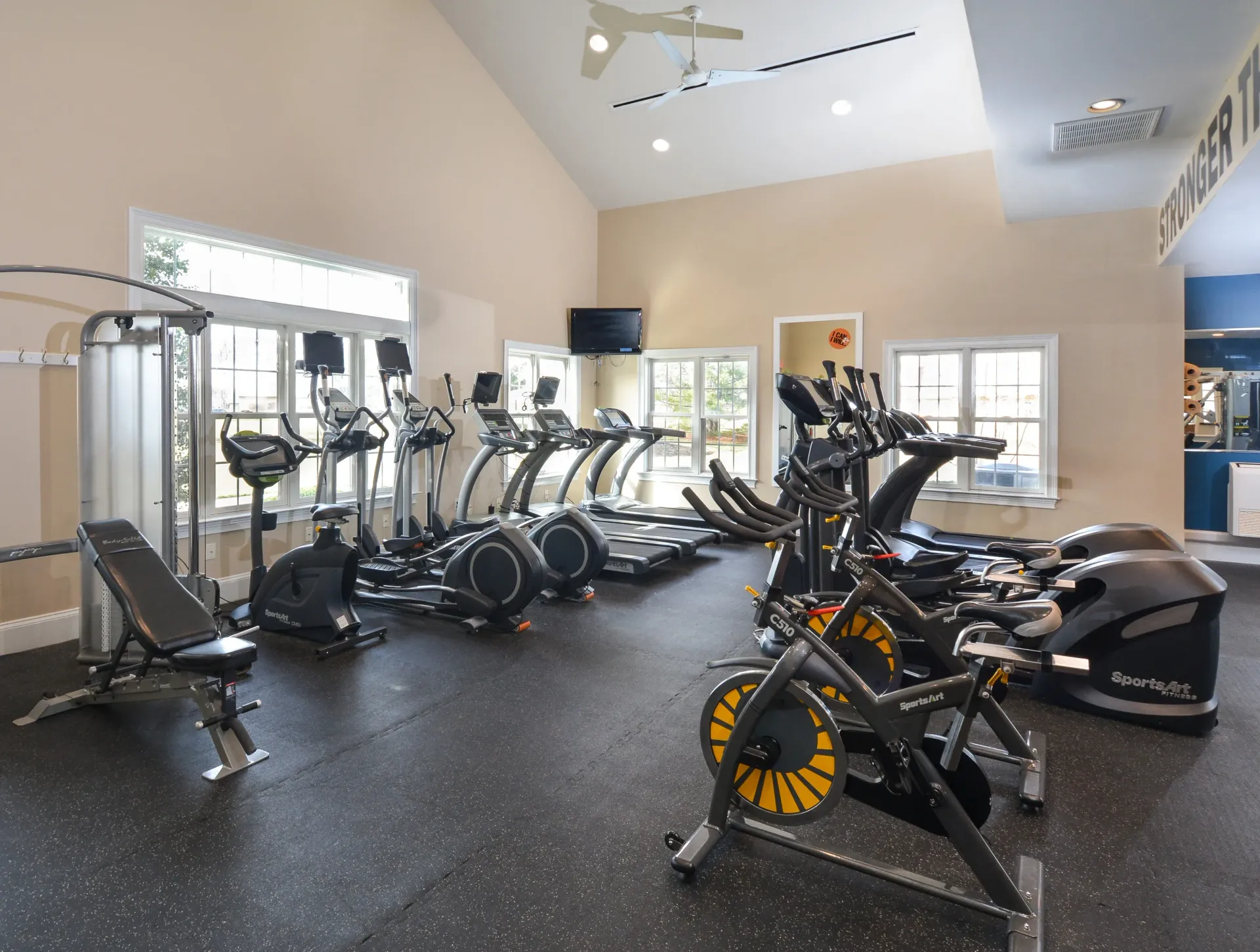 Indoor community gym with treadmills, ellipticals, and stationary bikes.