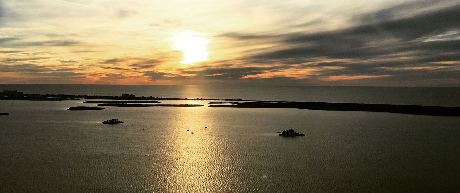 The Sun Is Setting Over The Ocean With Boats — St. Petersburg, FL — Executive Helicopter Tours
