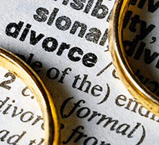 Two gold rings on top of the dictionary definition of the word Divorce