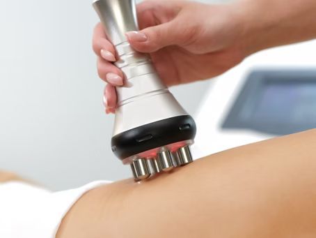 A woman is getting a cavitation treatment on her lower back.
