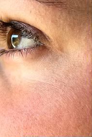 A close up of a woman 's eye with long eyelashes.