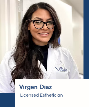 A woman wearing glasses and a lab coat is smiling for the camera.