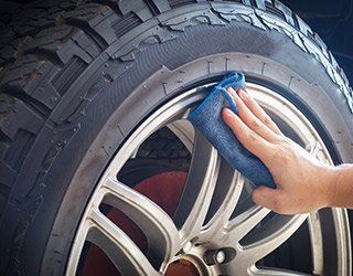 Mechanic Wiping Tire - Auto Service in Tampa, FL