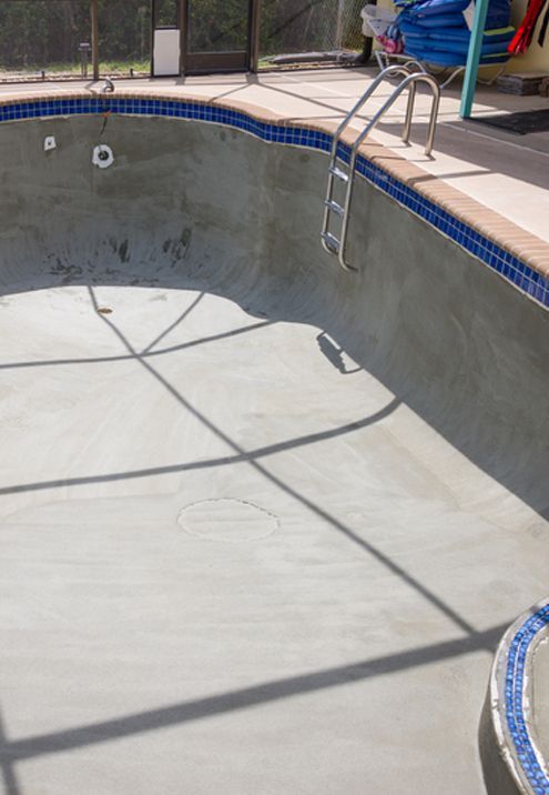 An empty swimming pool with a ladder in it