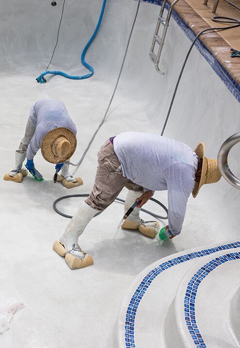 Two men are working on a swimming pool.