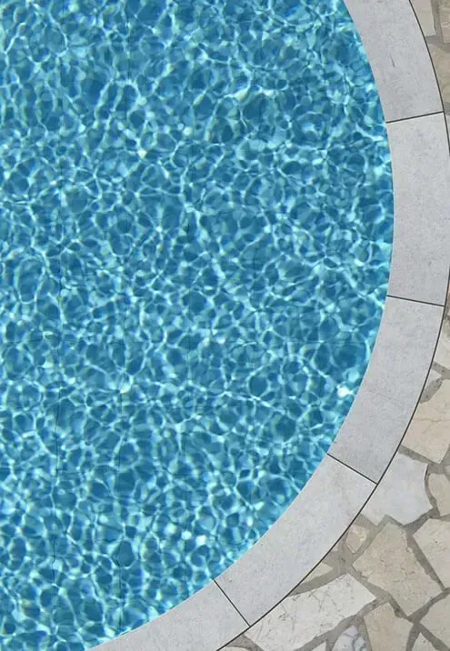 A swimming pool with blue water and a white border