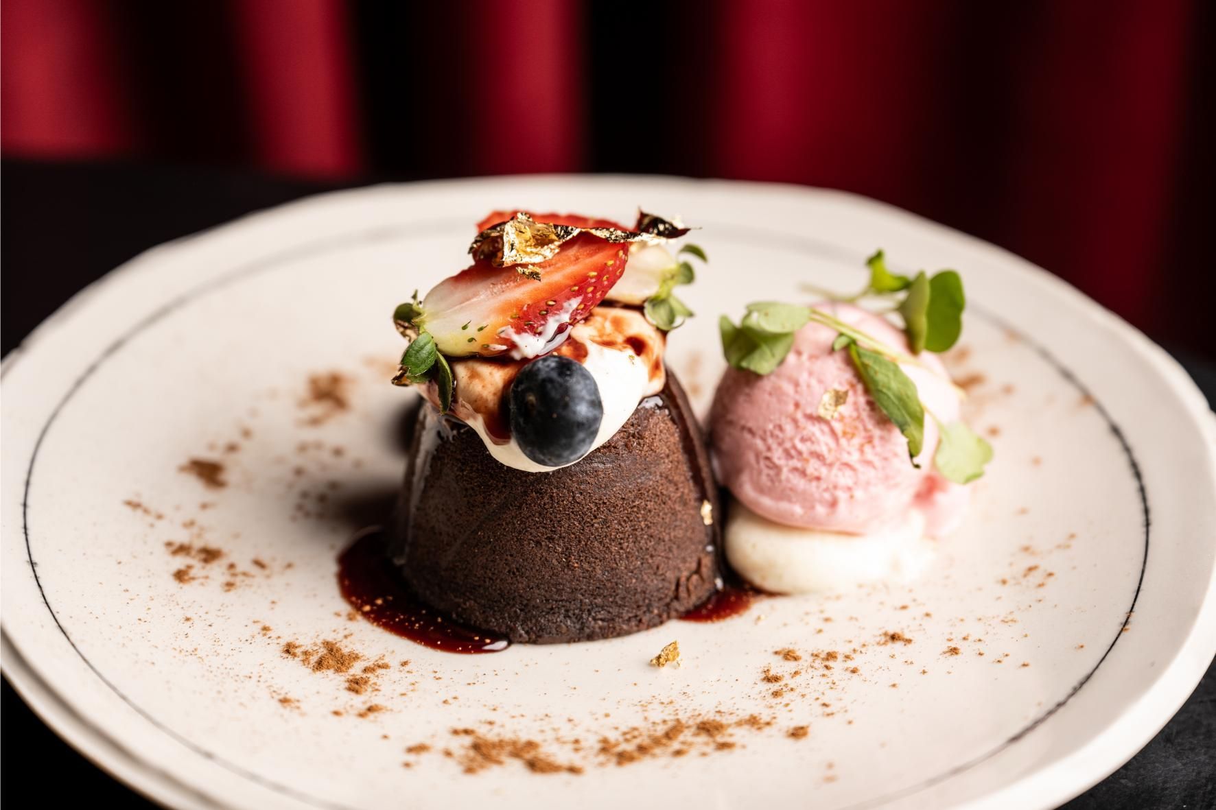 Pastel de lava de chocolate con helado y bayas en un plato.