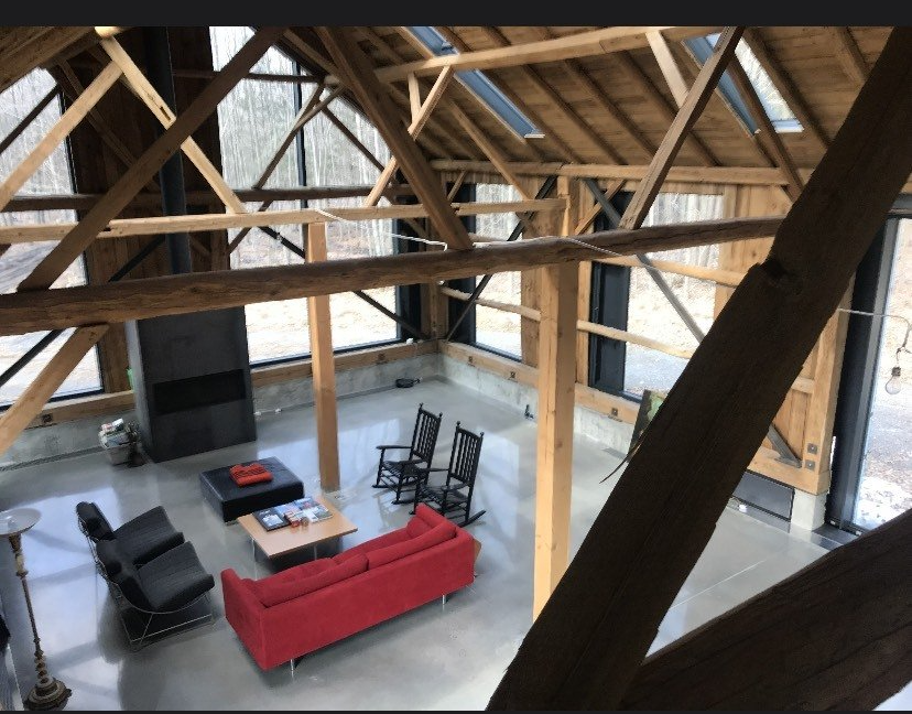 A living room with a red couch and black chairs
