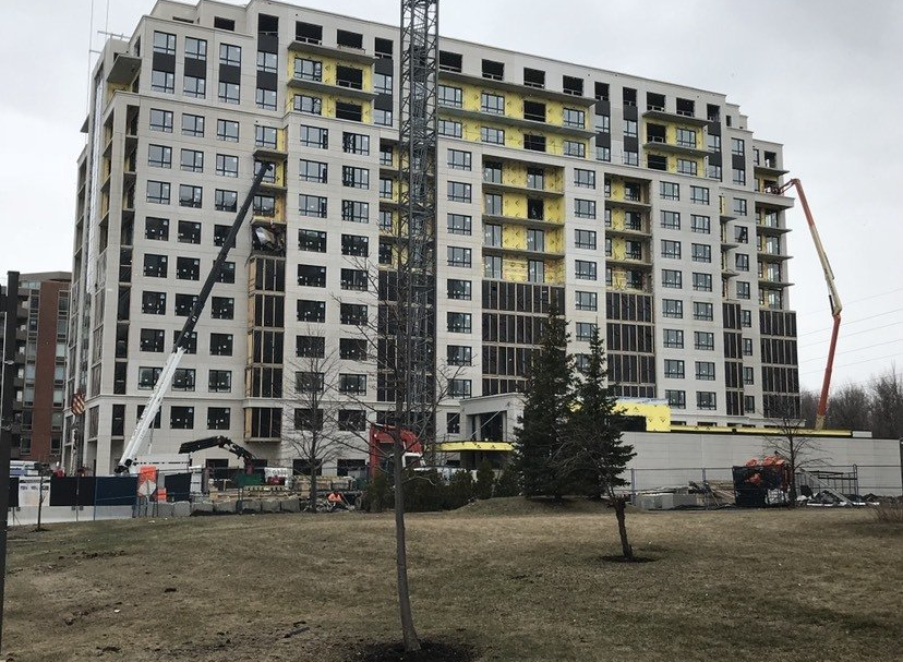 A large building under construction with a crane in front of it