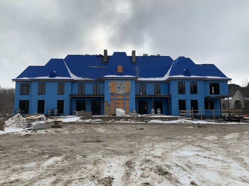 A large blue house is being built in the snow