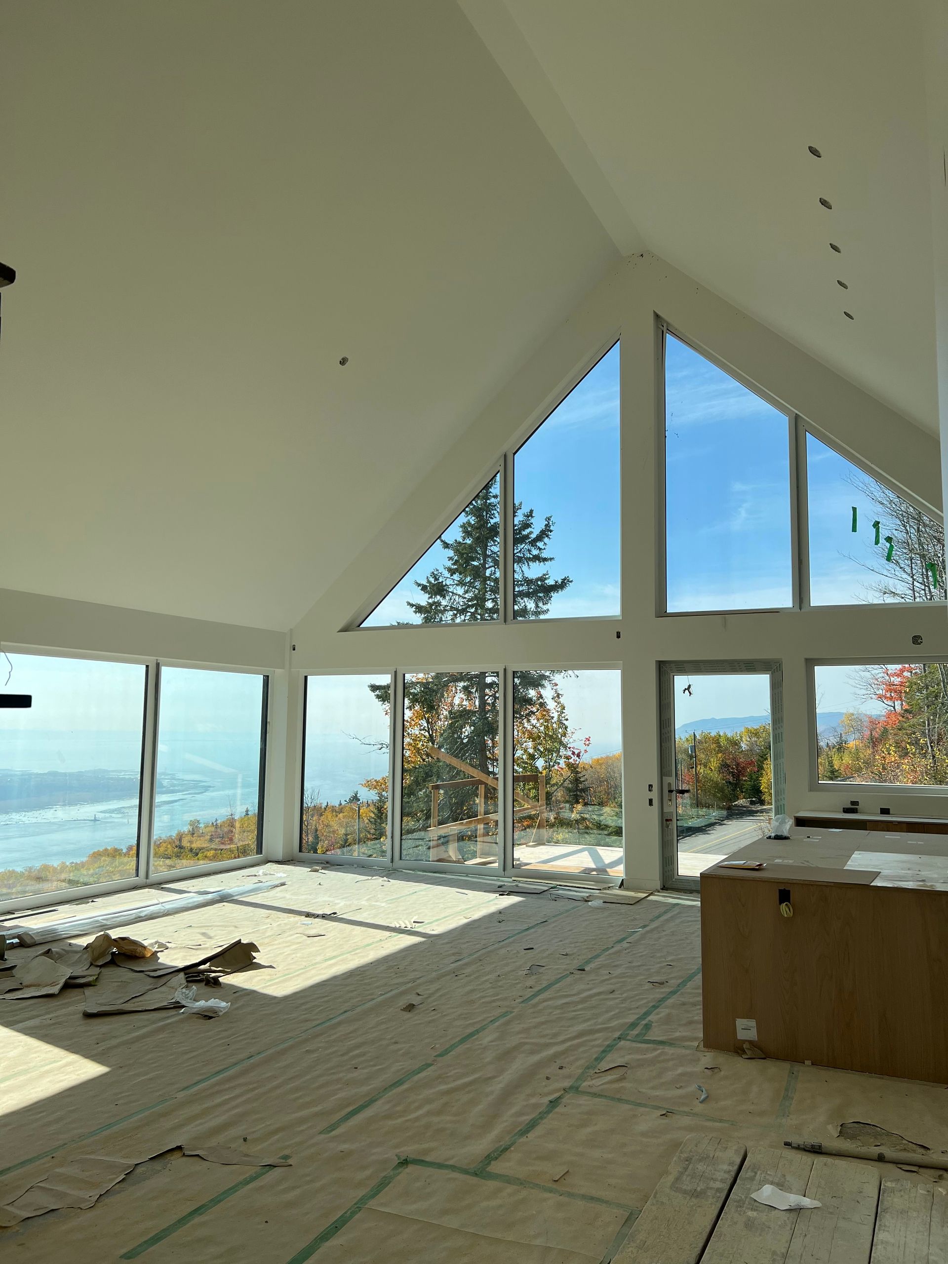 A large room with a lot of windows and a ceiling fan