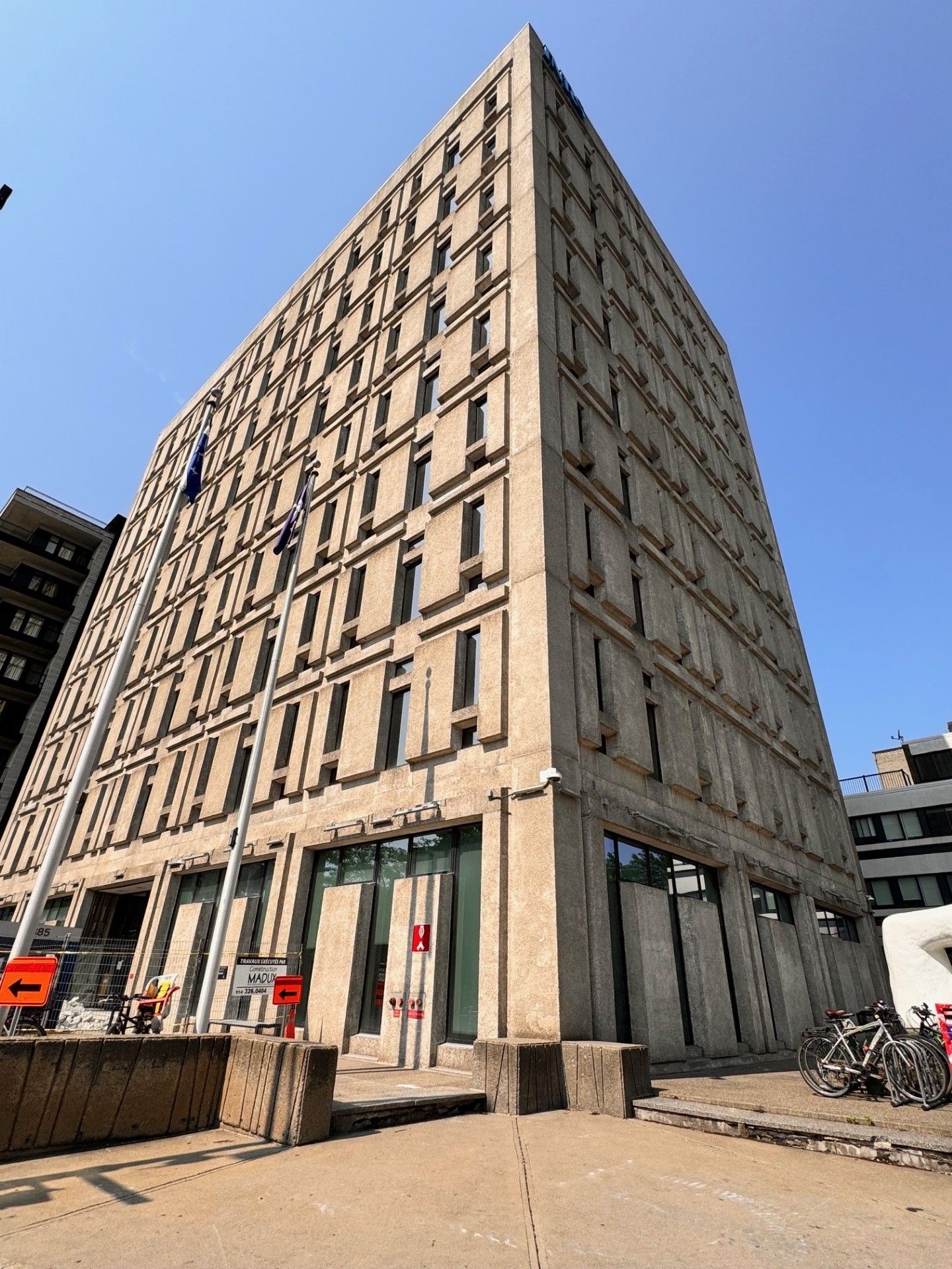 A tall building with a lot of windows and a blue sky in the background