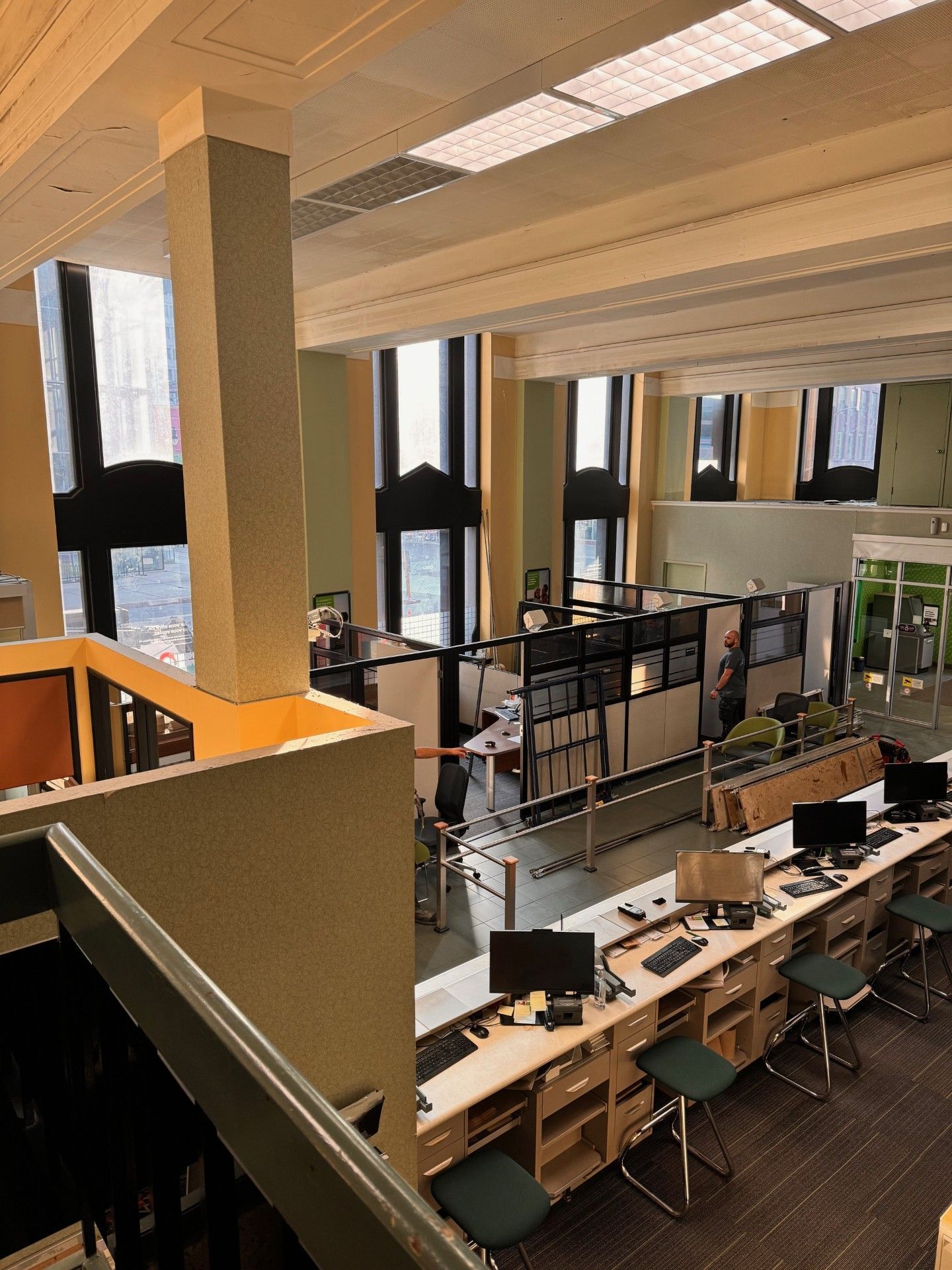 L'intérieur d'une bibliothèque avec des ordinateurs et des postes de travail. La lumière naturelle inonde la pièce.