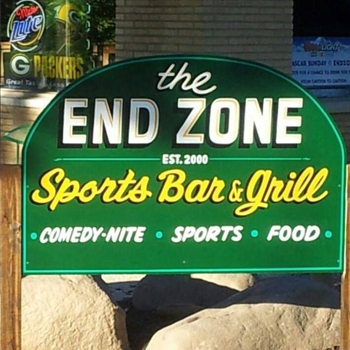 A green sign for the end zone sports bar and grill