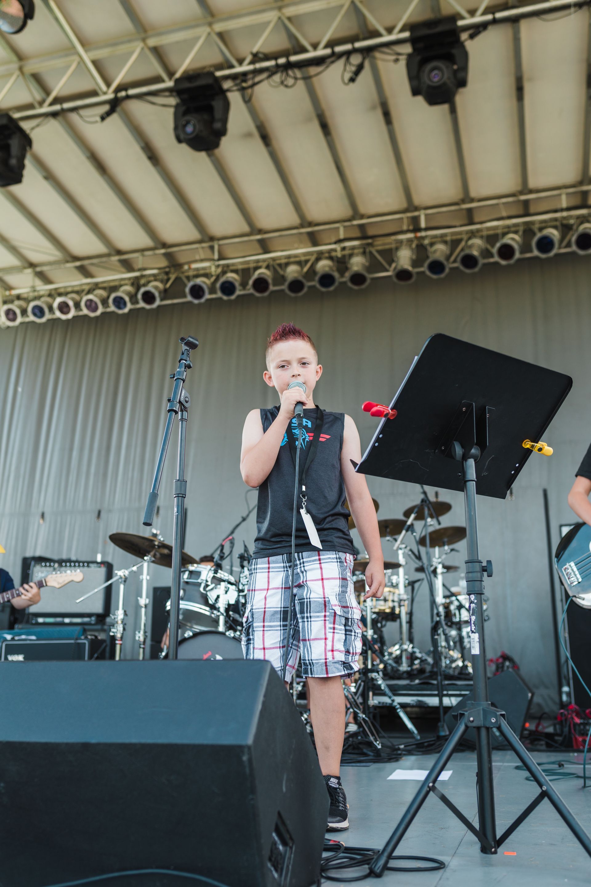 A young man singing into a microphone on a stage