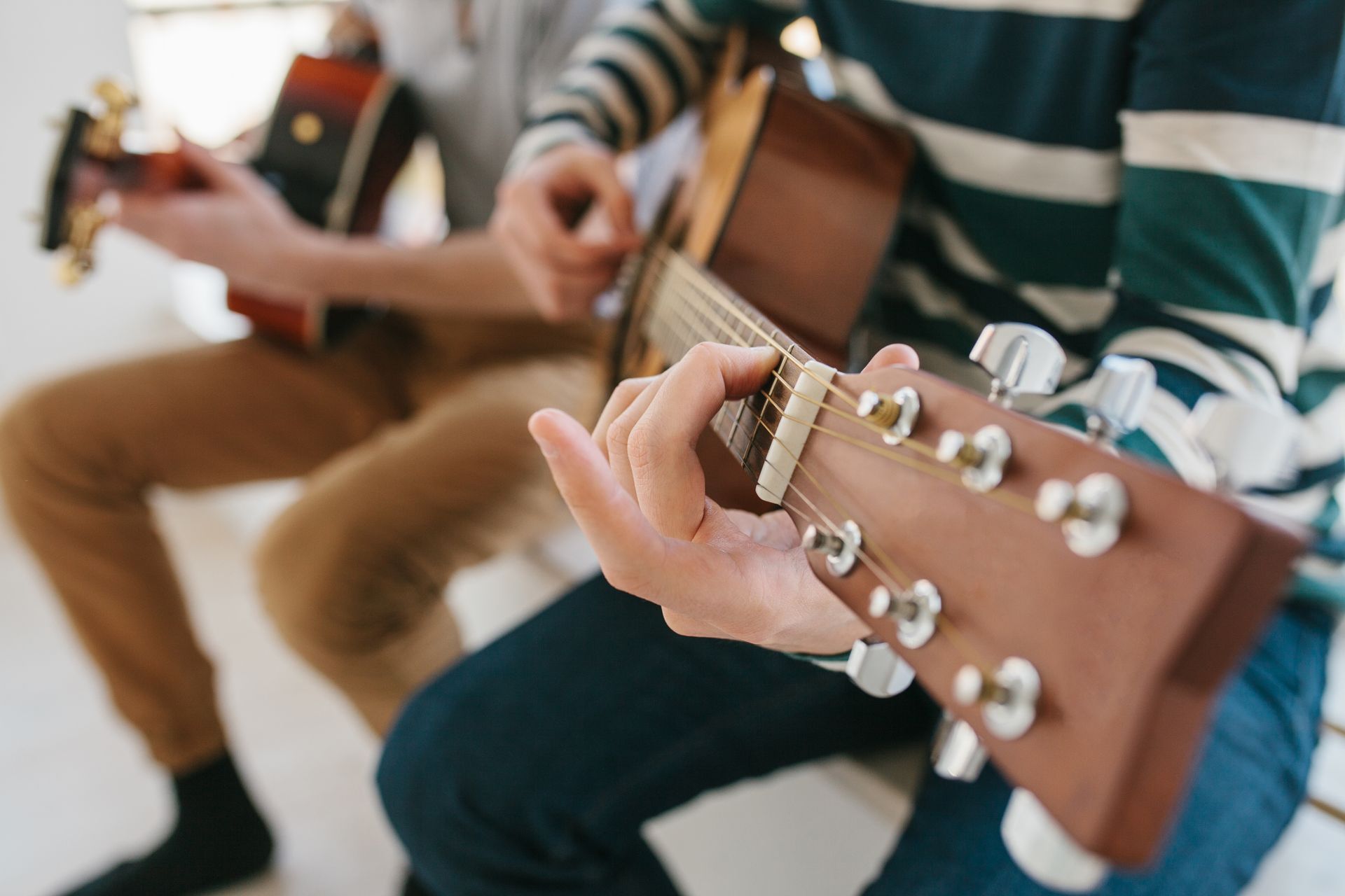 A group of people are playing guitars in a room.