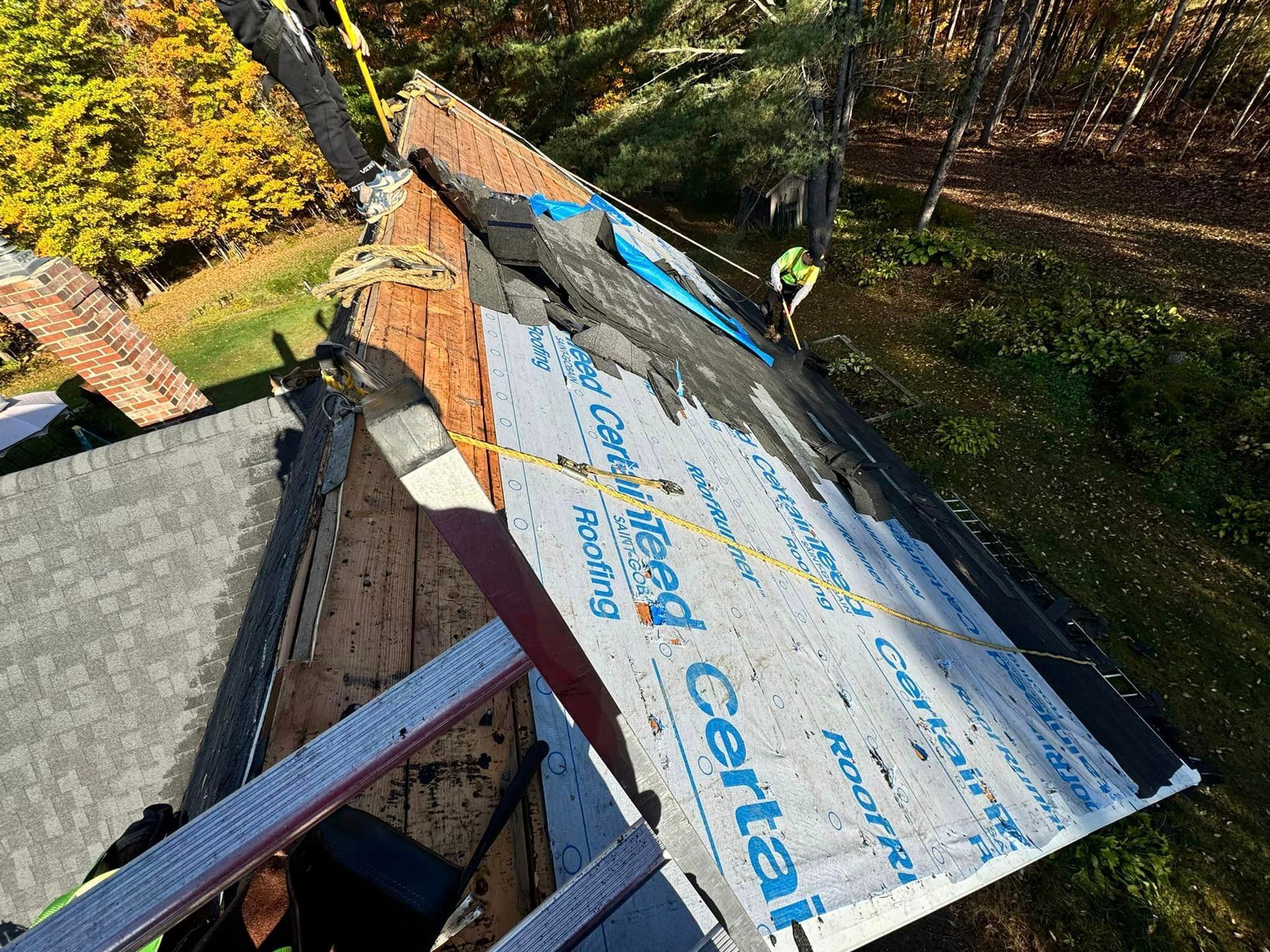 A man is working on the roof of a house.