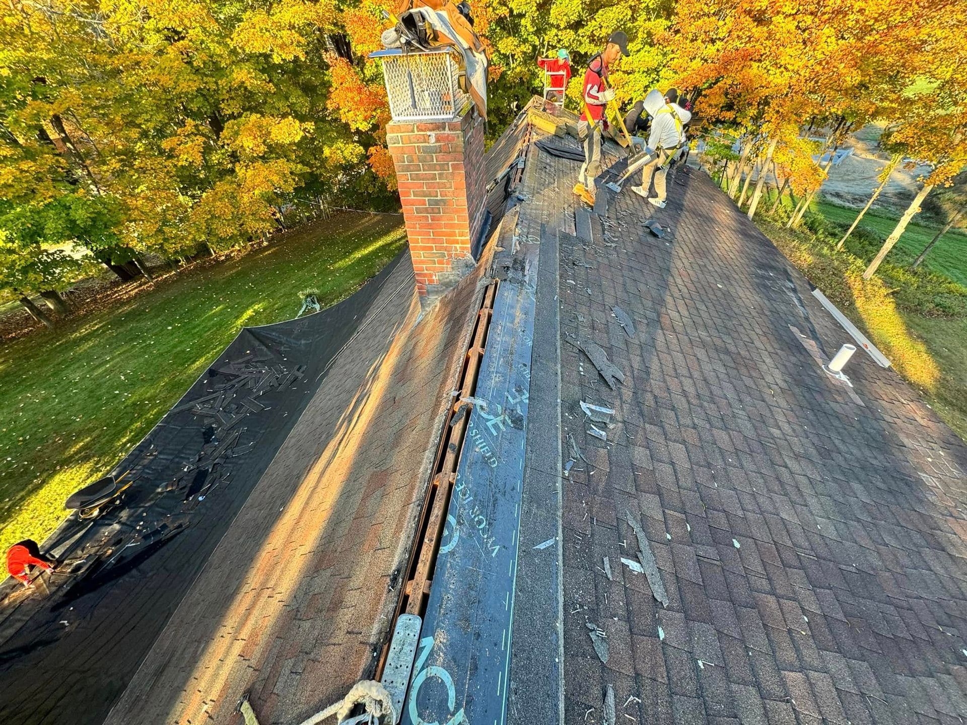 A group of people are working on the roof of a house.