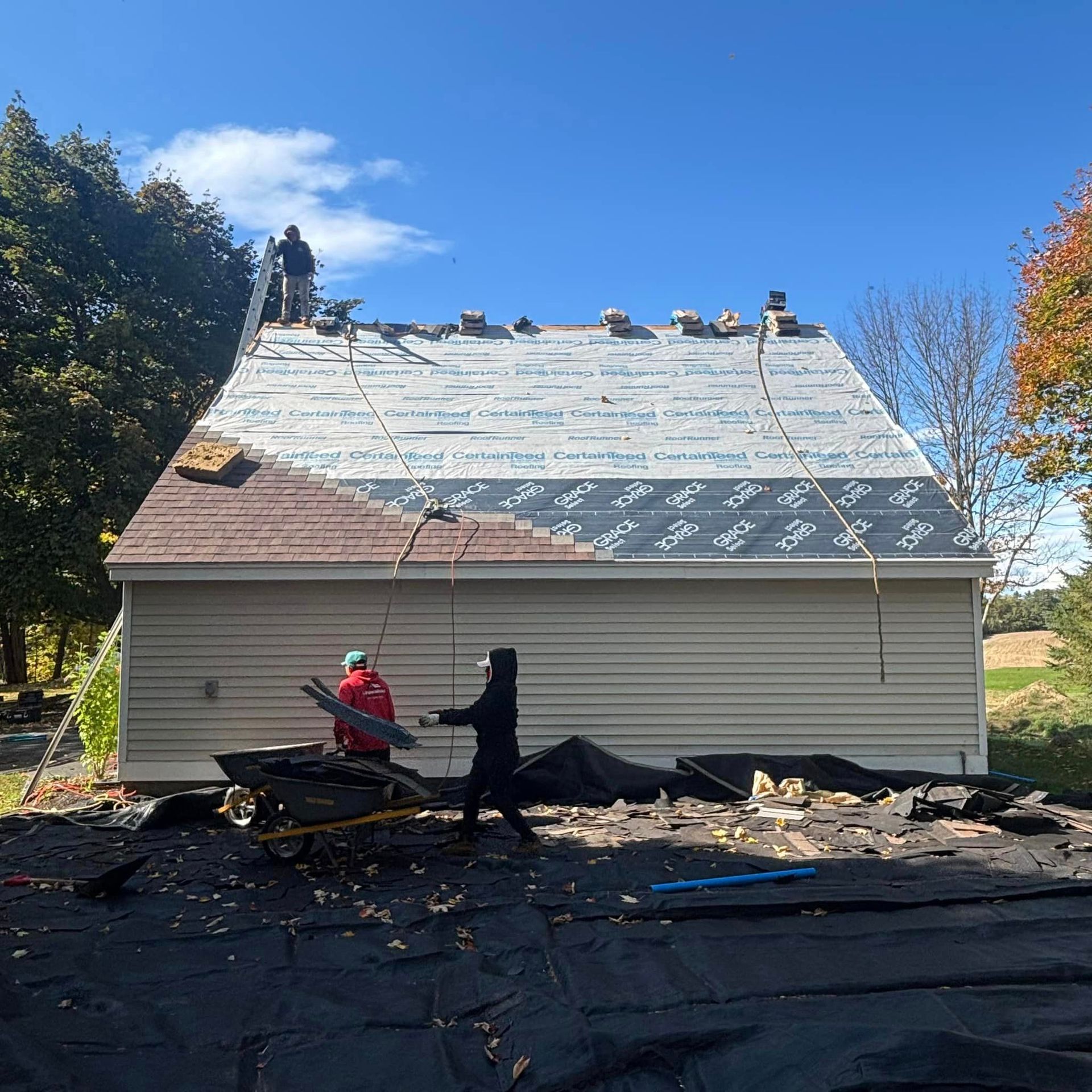 Two men are working on the roof of a house.