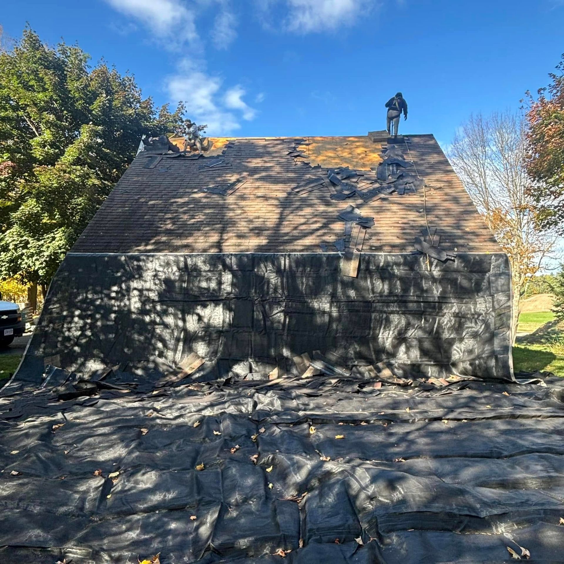 A man is standing on top of a wooden roof.