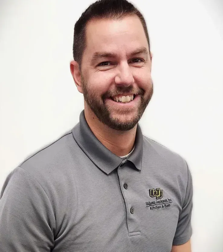 Smiling man in a gray striped polo shirt against a white background