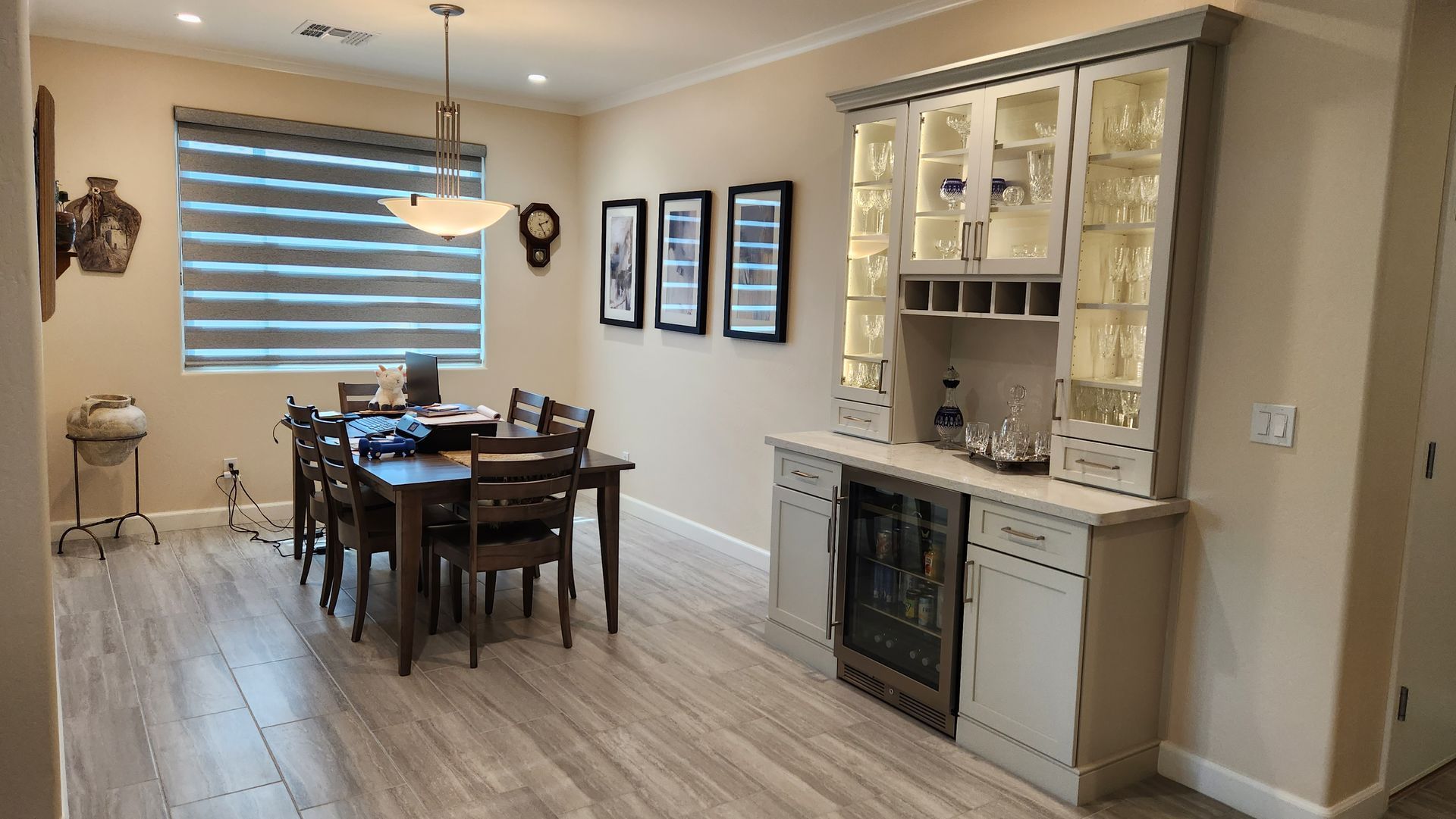 Dining room with a dark wood table, chandelier, and beige built-in cabinet in a bright home interior