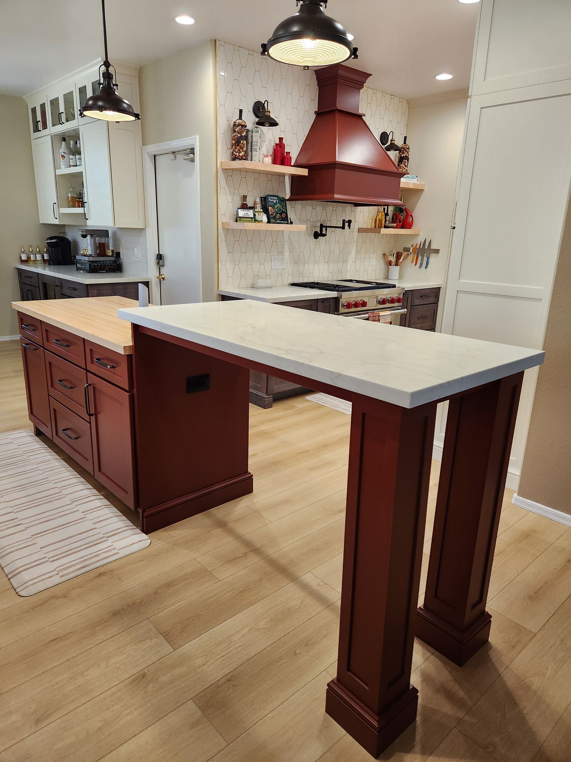 Modern kitchen with white island, dark wood cabinets, and hanging pendant lights