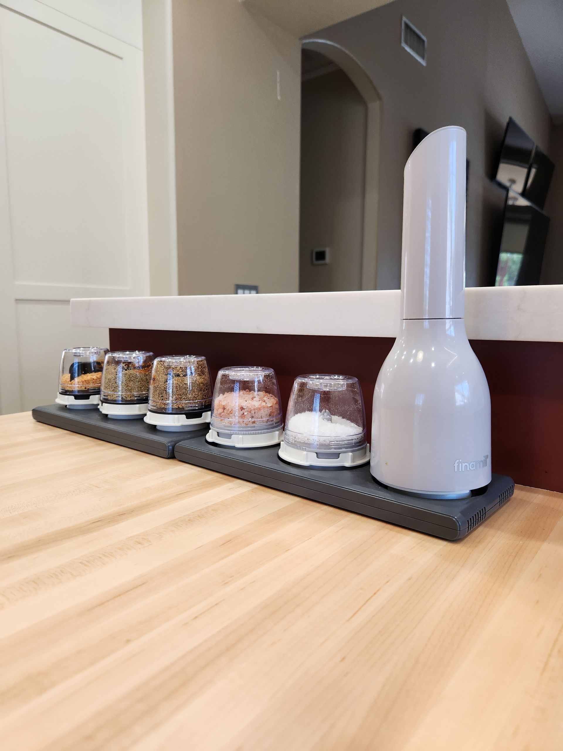 White vase and glass candle holders lined on a wooden counter in a modern home interior