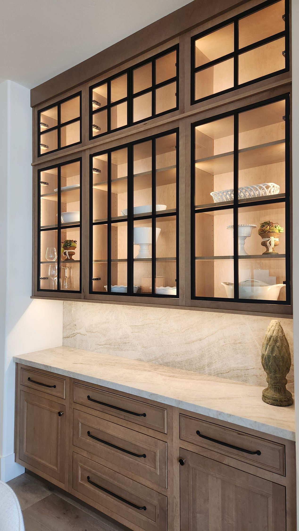 Built-in wood vanity with marble countertop and large black-framed mirror cabinets