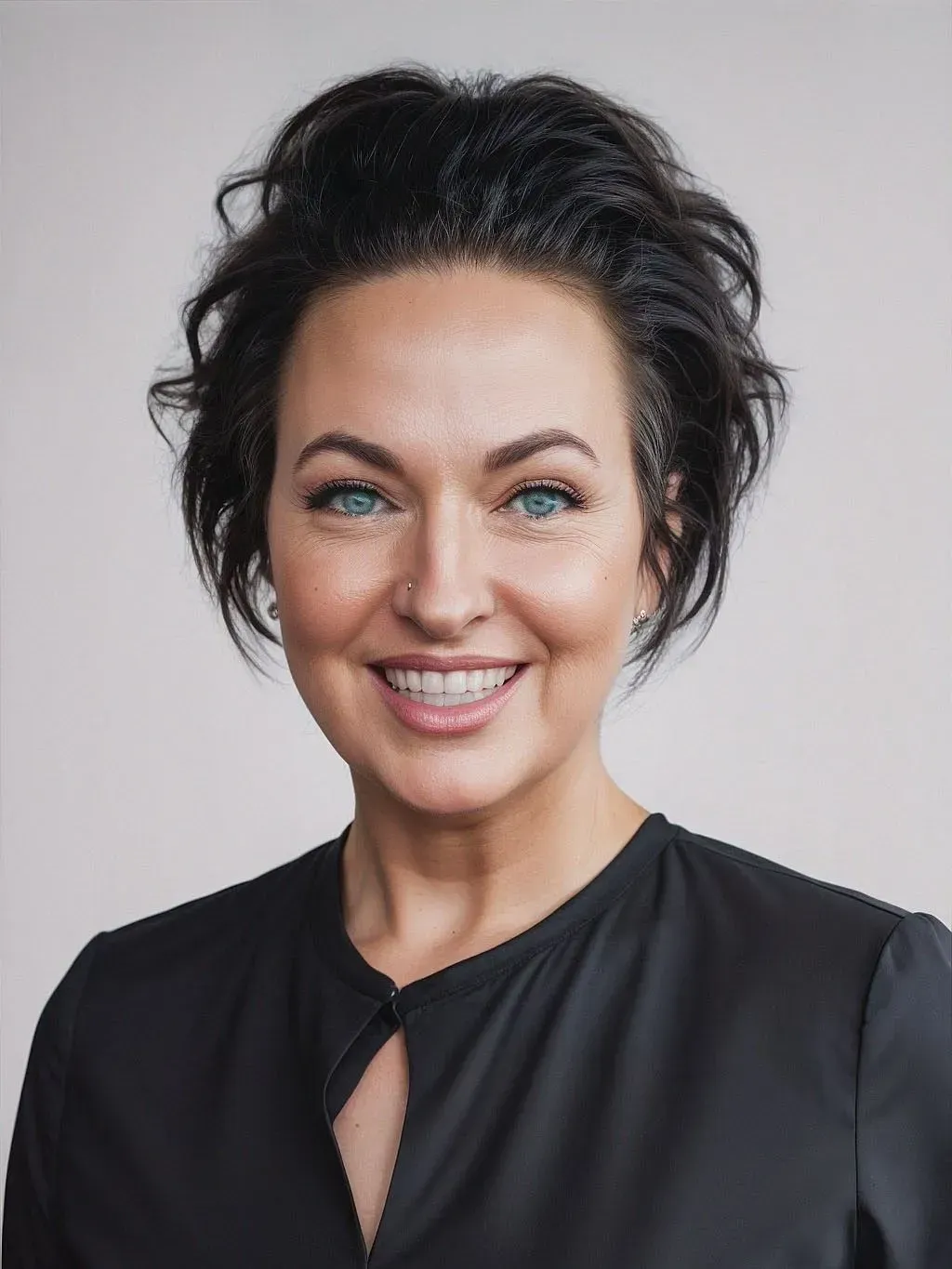Smiling woman with dark hair in a black top against a light gray background