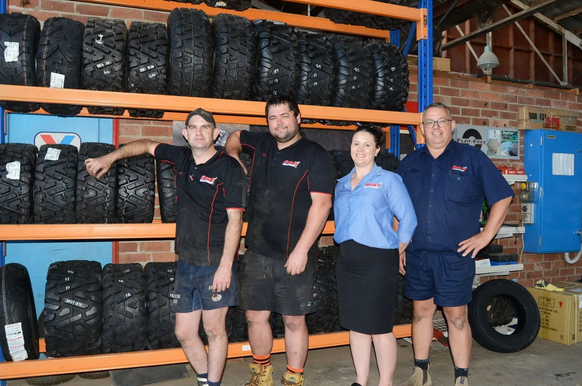 Four People Standing in Front of Shelves of Tires in a Tire Shop — Ben's Tyres in Wellington, NSW
