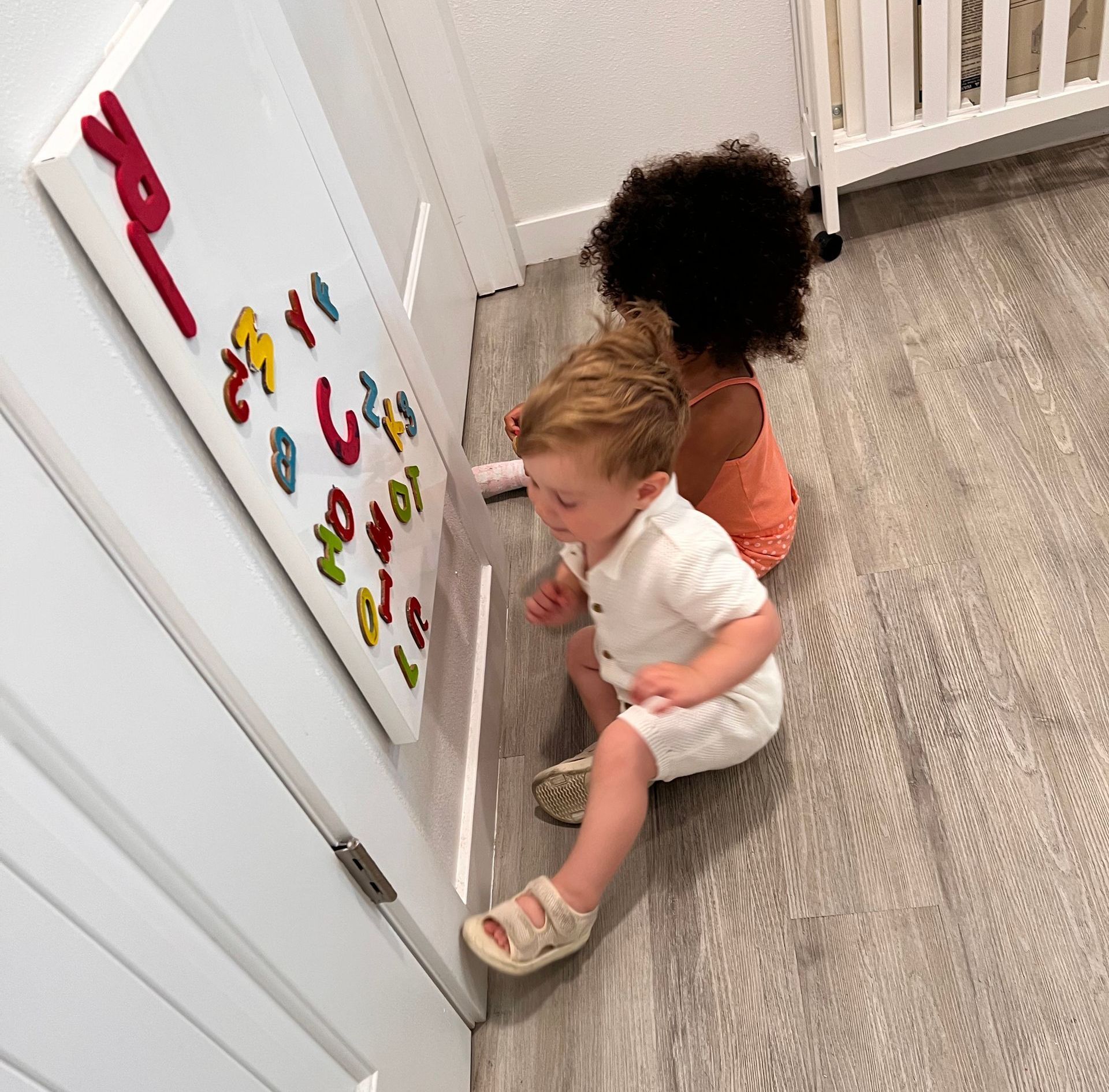 A group of children are sitting around a table playing with toys.