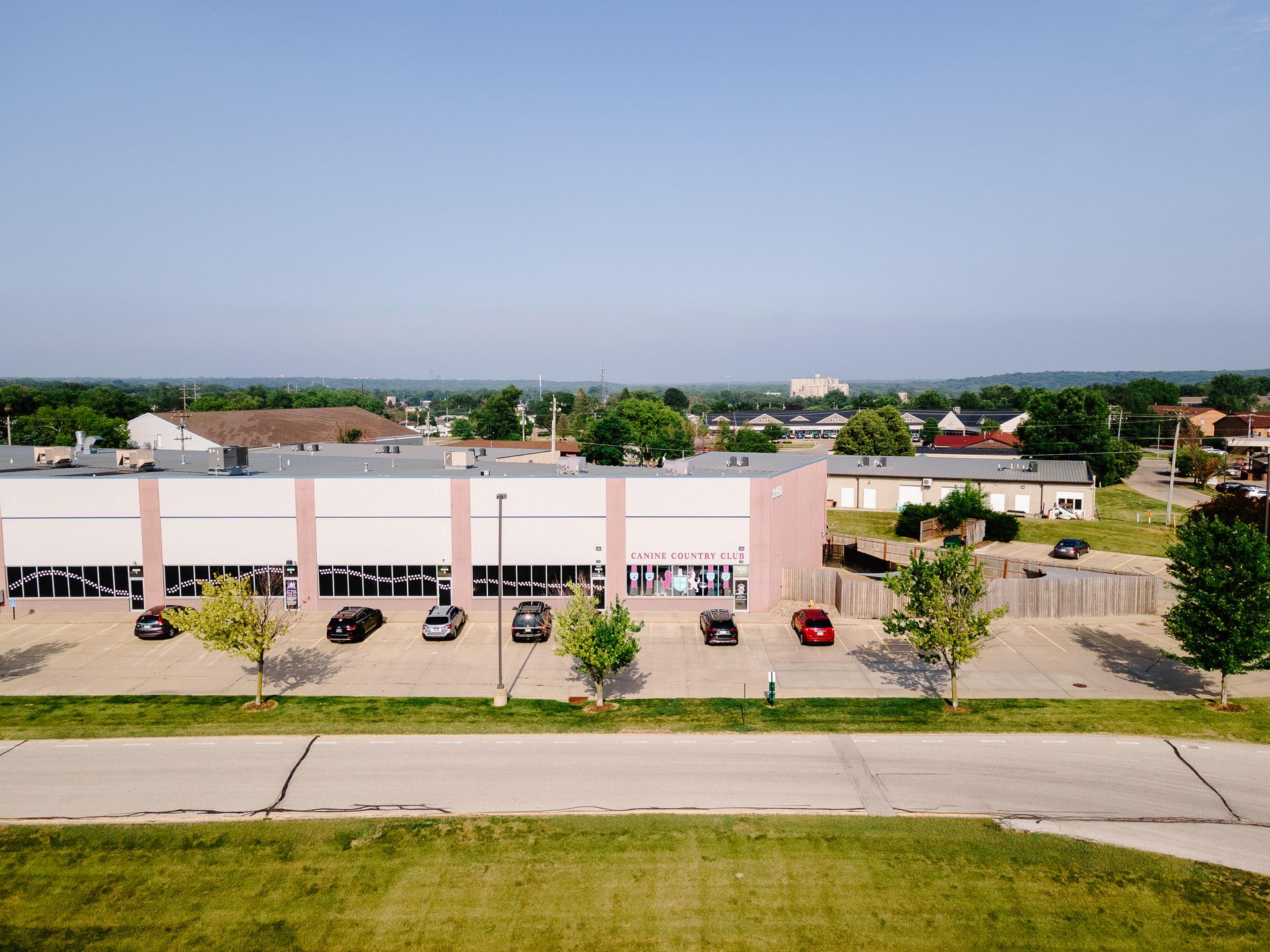 An aerial view of a large building with cars parked in front of it.