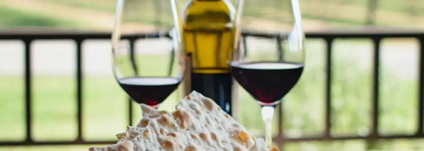 Two glasses of red wine with a bottle on a patio table in Solvang, perfect for a unique wine country stay.