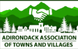Logo: White handshake icon over silhouette of town buildings and mountains with green trees. Text: ADIRONDACK ASSOCIATION.
