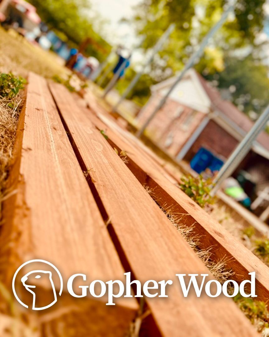 Wood planks on the ground with a blurry building and logo of 