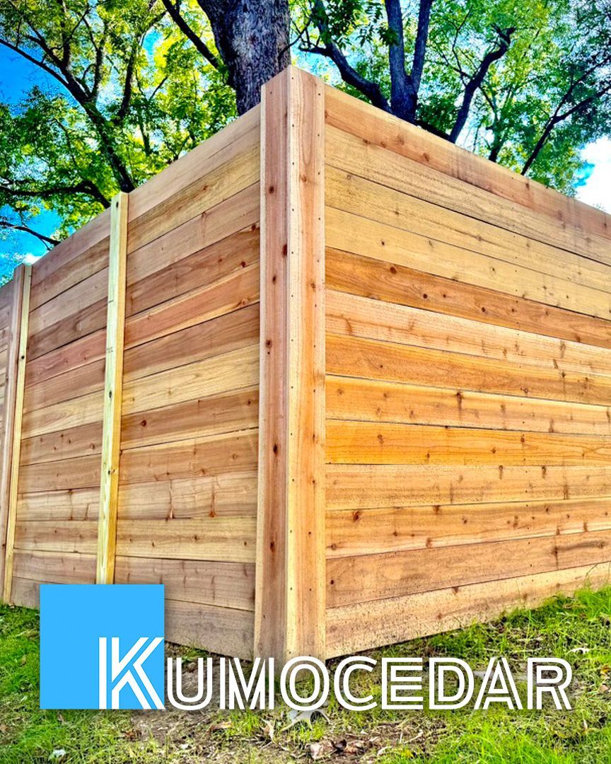 Wooden fence with a tree in the background; a company logo at the bottom.