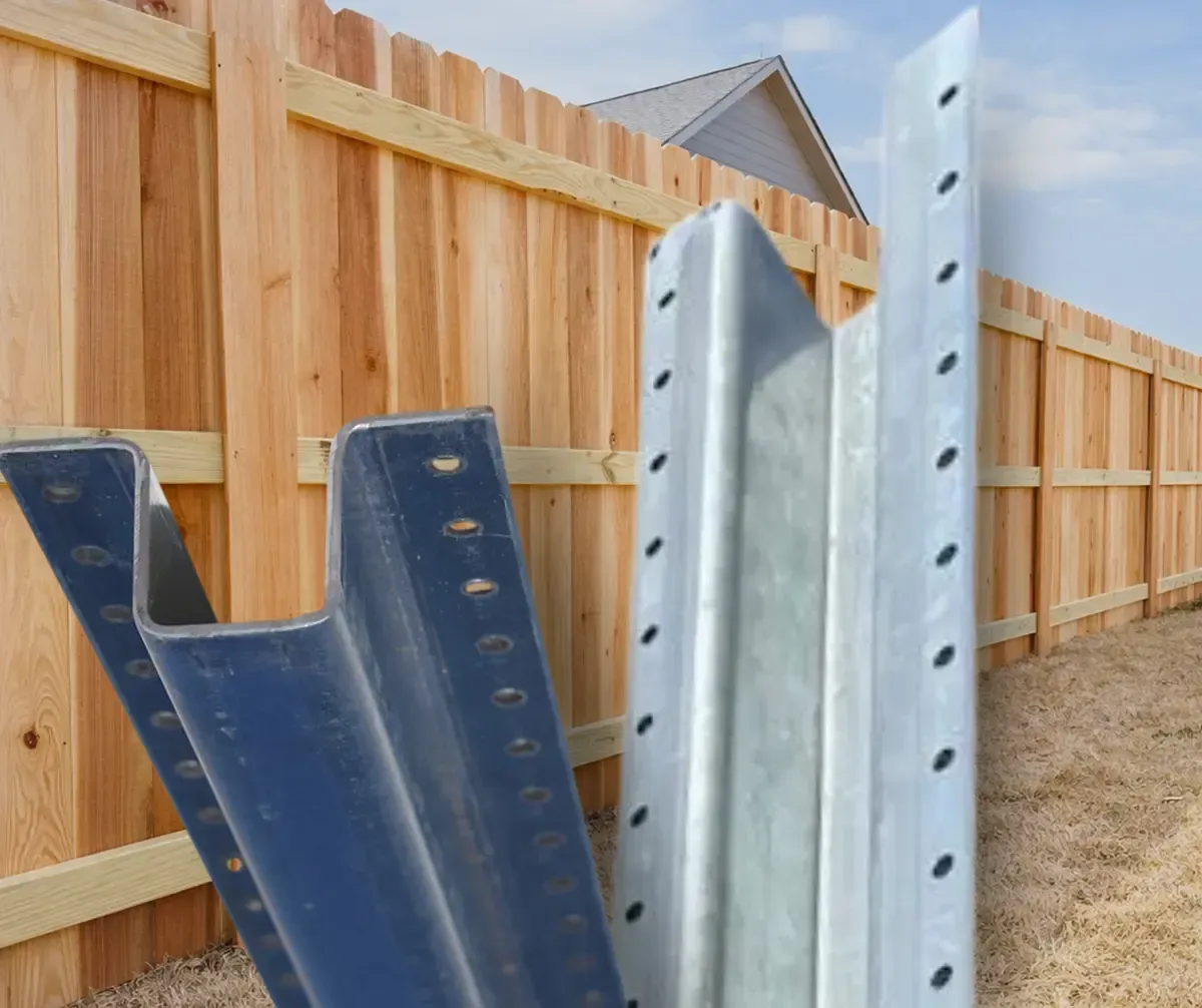 Metal fence posts leaning against a wooden privacy fence in a yard.