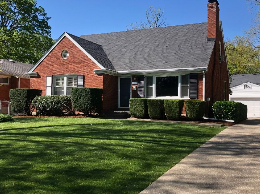 A Brick House with a Gray Roof and a Lush Green Lawn – Louisville, KY – Wayne's Lawn Service