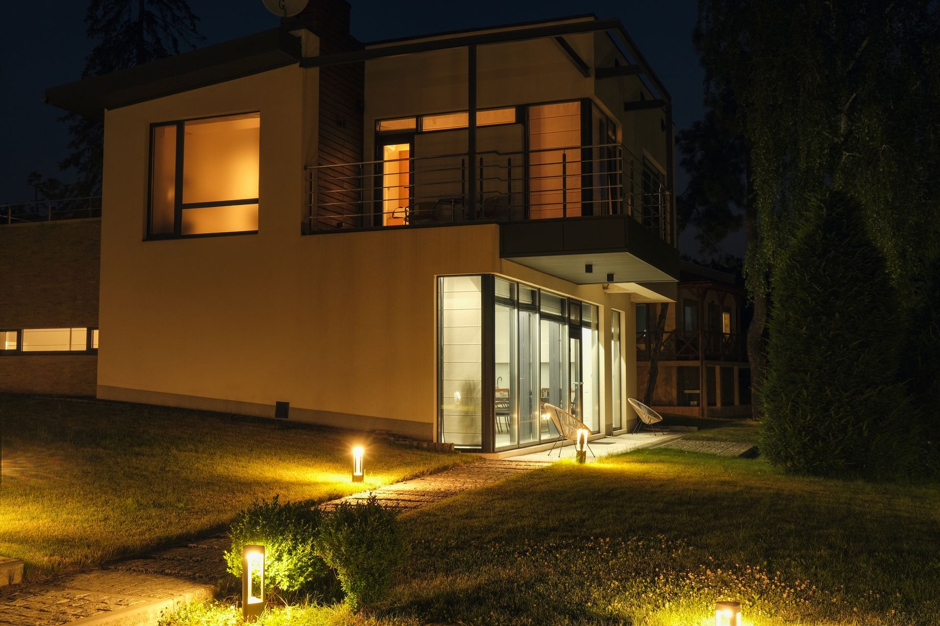 Modern country residence at night, with landscape lighting on. Modern country residence at night, with landscape lighting on.