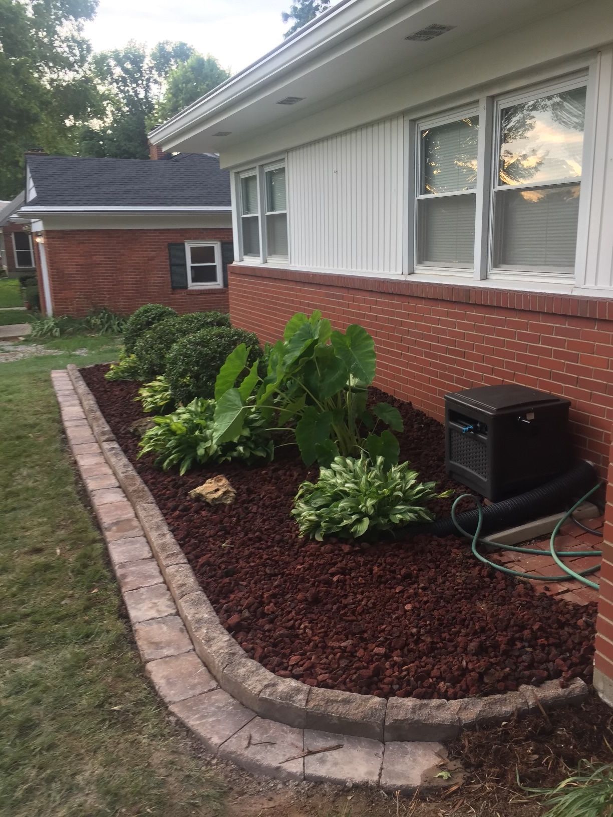 A Brick House with a Garden in Front of it – Louisville, KY – Wayne's Lawn Service