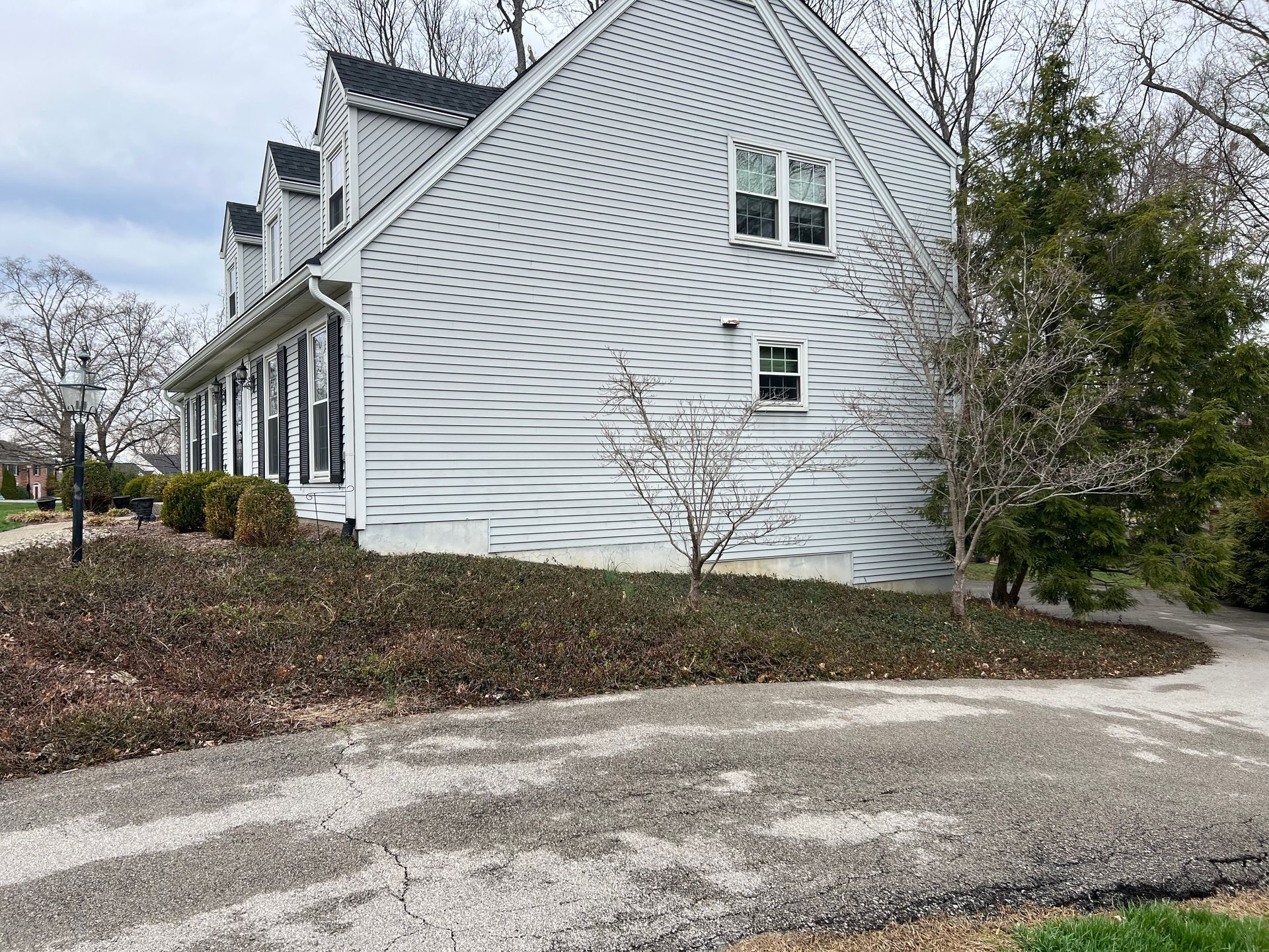 A White House With a Black Roof and a Driveway in Front of it – Louisville, KY – Wayne's Lawn Service